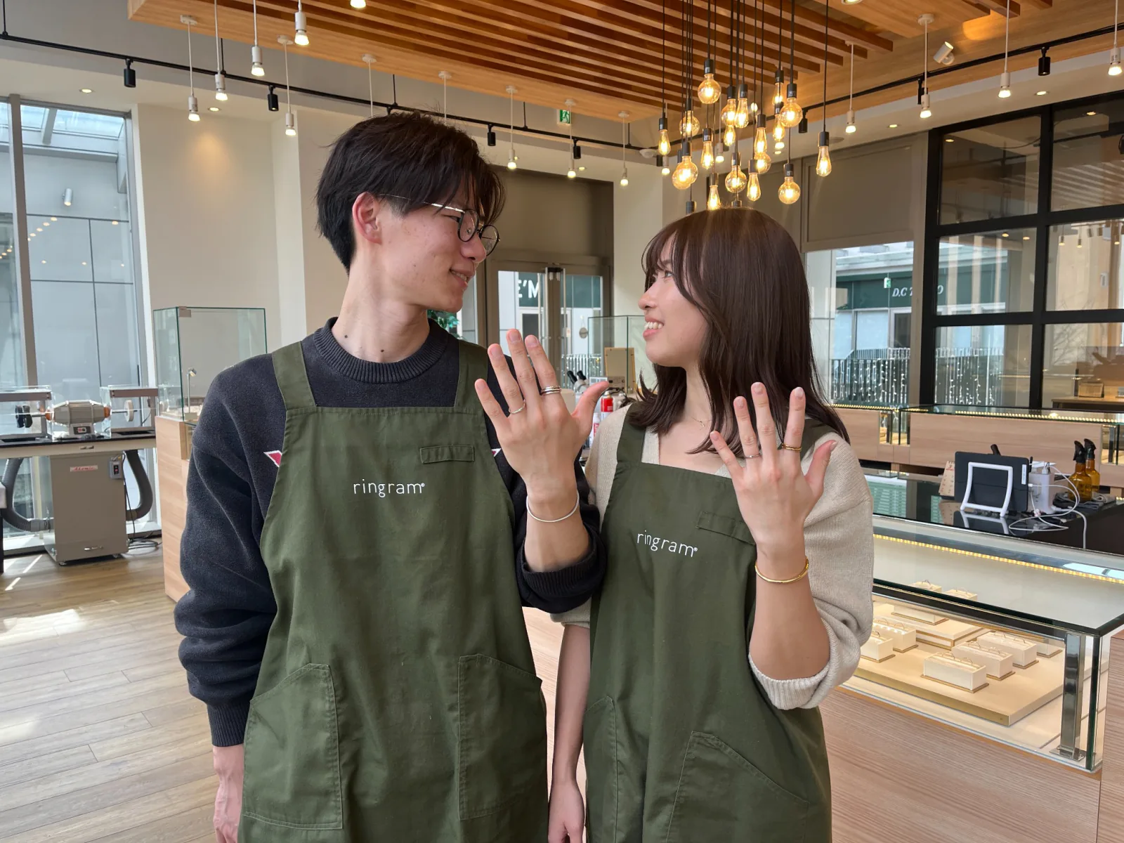指輪を見せながら向かい合う二人の横写真
